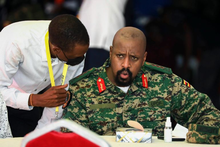 ap_68e3aee979cd0-1759751913 FILE - Then Lt. Gen. Muhoozi Kainerugaba, right, son of Uganda's President Yoweri Museveni, speaks to Attorney General Kiryowa Kiwanuka, left, at a "thanksgiving" ceremony in Entebbe, Uganda on May 7, 2022. On Twitter, the Ugandan president's son Muhoozi Kainerugaba has mused about invading neighboring Kenya but while many of his tweets are dismissed as laughable, the ones about succeeding his father are a source of concern. (AP Photo/Hajarah Nalwadda, File)