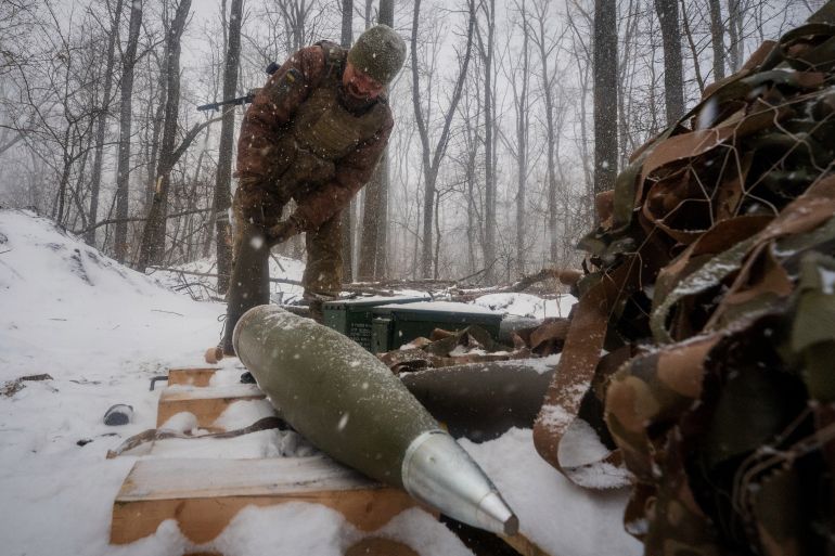 A Ukrainian serviceman of the 48th separate artillery brigade prepares artillery shells before firing towards Russian positions on the frontline in Kharkiv region, Ukraine, Wednesday, Feb. 18, 2026. (AP Photo/Andrii Marienko)