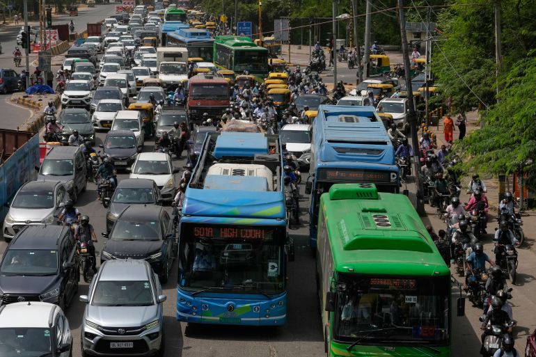 ap_6aac14ca3ab3d-1789662410 Electric buses move through dense traffic alongside other vehicles and scooters in New Delhi, India, Tuesday, July 14, 2026. (AP Photo/Manish Swarup)