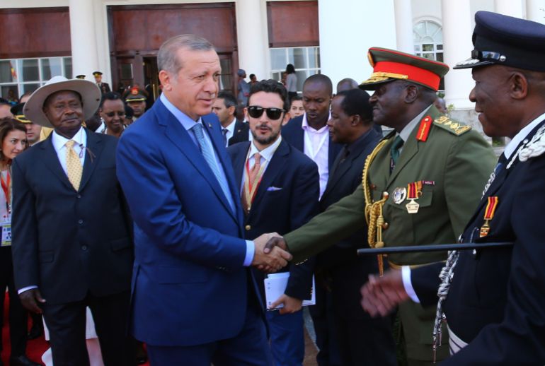 Uganda's long-time president Yoweri Museveni, left, watches as Turkey's President Recep Tayyip Erdogan shakes hands with Ugandan military generals during a welcome ceremony in the capital Kampala, Uganda, Wednesday, June 1, 2016. Museveni was sworn in earlier in May for a fifth term taking him into his fourth decade in power, amid arrests of opposition politicians and a shutdown of social media. Erdogan is on a two-day state visit.(Kayhan Ozer, Presidential Press Service/Pool via AP)
