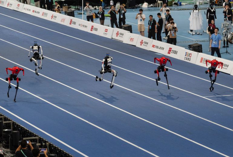 BEIJING, CHINA - AUGUST 25: Tian Gong Ultra humanoid robots, white, and Honor Robots, red, run in a heat in the large robot category of the 100 meter at the 2nd World Robot Games at National Speed Skating Oval on August 25, 2026 in Beijing, China. A Tian Gong Ultra ran the 100 meter in 9.39 seconds at the games' opening ceremony on August 22nd, beating Usain Bolt's long standing record. The games, that feature hundreds of humanoid robots competing in track and field, tennis, boxing, football, working skills among many others, runs from August 22-26th. (Photo by Kevin Frayer/Getty Images)
