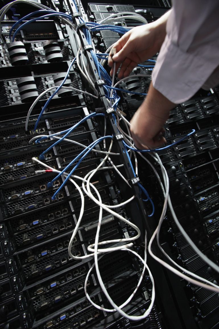 getty_6aafbdb310-1789902259 HANOVER, GERMANY - MARCH 05: A worker connects IBM Intelligent Cluster modules, including servers and data storage devices, of a Data Center at the IBM stand the day before the CeBIT 2012 technology trade fair officially opens to the public on March 5, 2012 in Hanover, Germany. CeBIT 2012, the world's largest information technology trade fair, will run from March 6-10, and advances in cloud computing are a major feature this year. (Photo by Sean Gallup/Getty Images)