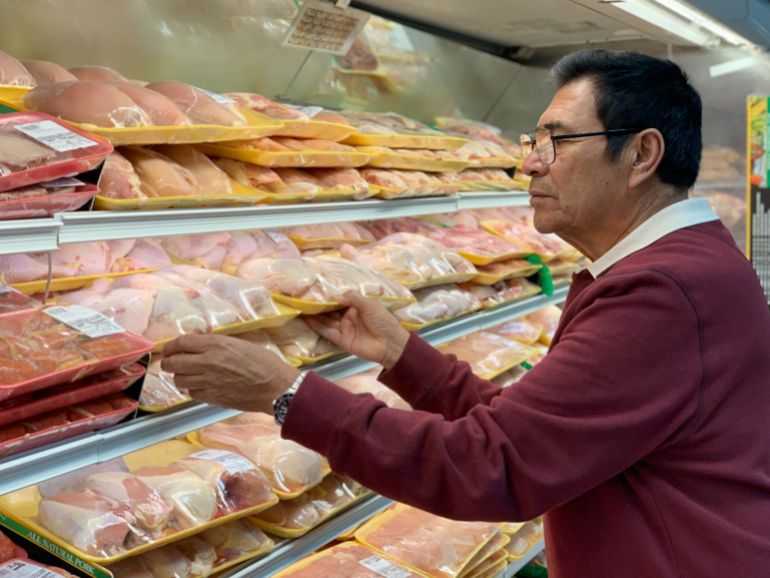 Male Mexican senior citizen who is buying packaged chicken at the Hispanic grocery store in Commerce, California