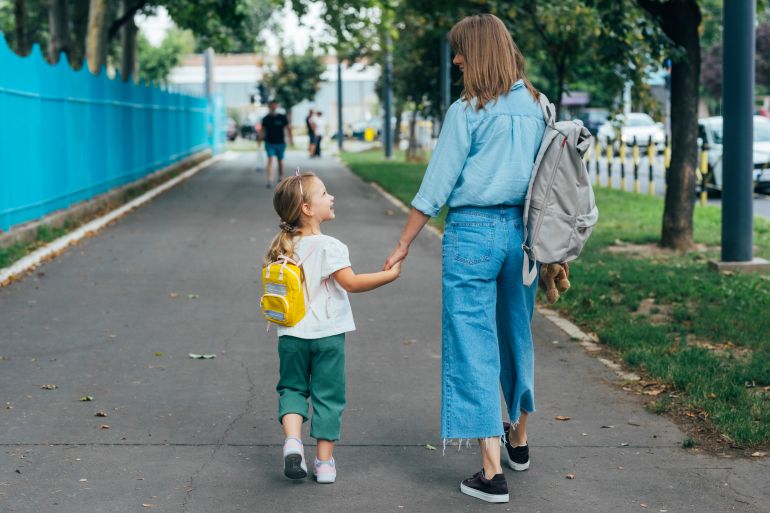 gettyimages-1331345416-1788441028 Anonymous Mother walking together with her daughter, holding her hand