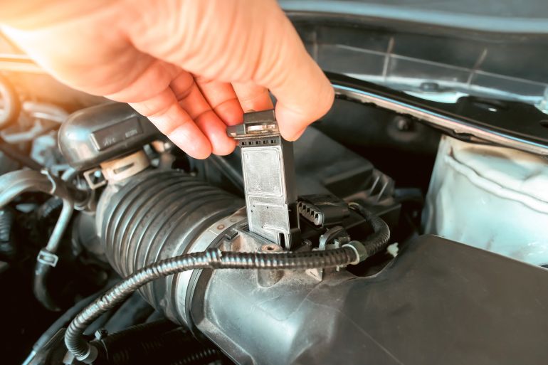 gettyimages-1447712639-1788727336 The mass air flow sensor is installed in the engine air intake manifold system by a auto mechanic, automotive part concept