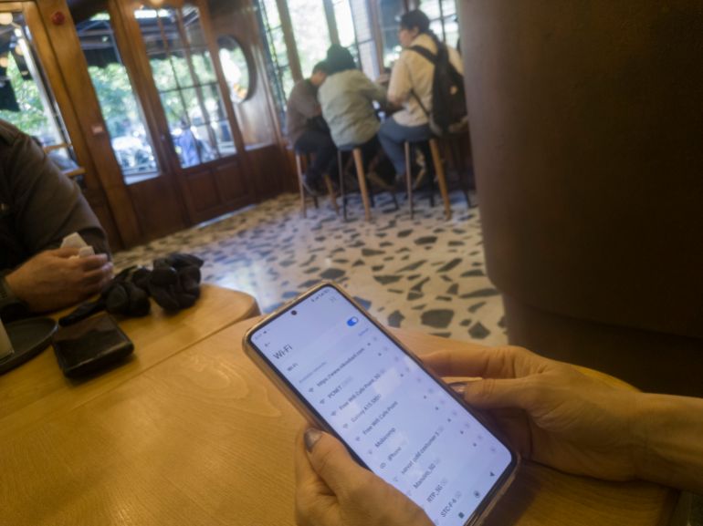 gettyimages-2277829045-1780353246 عودة الإنترنت في إيران A young Iranian woman attempts to connect to Wi-Fi on her cellphone while sitting at a cafe in downtown Tehran, Iran, on May 26, 2026. Internet access is being restored in Iran after being cut off for nearly three months, according to Iranian First Vice President Mohammad Reza Aref on his X account on Tuesday. (Photo by Morteza Nikoubazl/NurPhoto via Getty Images)