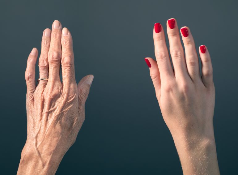 gettyimages-512160707-1790188021 Studio photograph of elderly woman's hand beside a younger woman's hand.