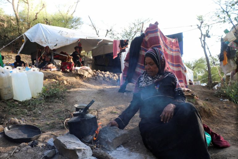 Aisha Muhammad cooks at a makeshift camp for internally displaced people after fleeing her home during clashes between Iran-aligned Houthi fighters and Saudi-backed Yemeni government forces, in Taiz province, Yemen September 13, 2026. REUTERS/Stringer REFILE - ADDING INFORMATION