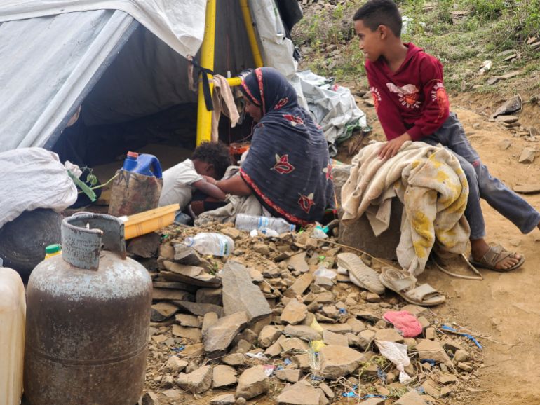 A woman sits with her children outside a tent at a makeshift camp for people displaced by clashes between Iran-aligned Houthi fighters and Saudi-backed Yemeni government forces, in Taiz province, Yemen, September 14, 2026. Picture taken with a mobile phone. REUTERS/Stringer
