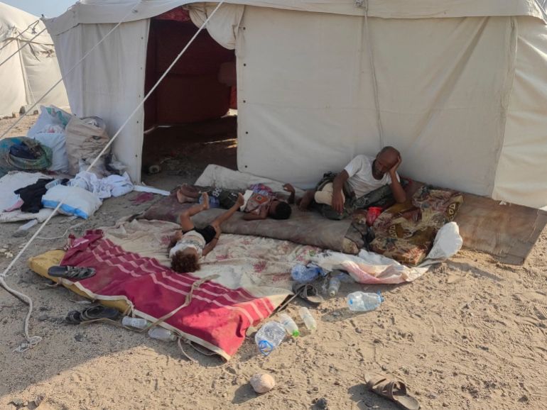 People rest outside a tent at a new camp for displaced people, following clashes between Iran-aligned Houthi fighters and Saudi-backed Yemeni government forces, near Aden, Yemen, September 13, 2026. Picture taken with a mobile phone. REUTERS/Stringer REFILE - ADDING INFORMATION