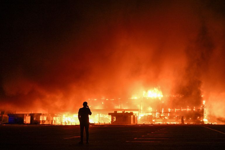 reuters_6aacdb28-1789713192 A resident stands in front of a shopping mall burning after a late evening Russian drone strike, amid Russia's attack on Ukraine, in Zaporizhzhia, Ukraine, September 17, 2026. REUTERS/Stringer