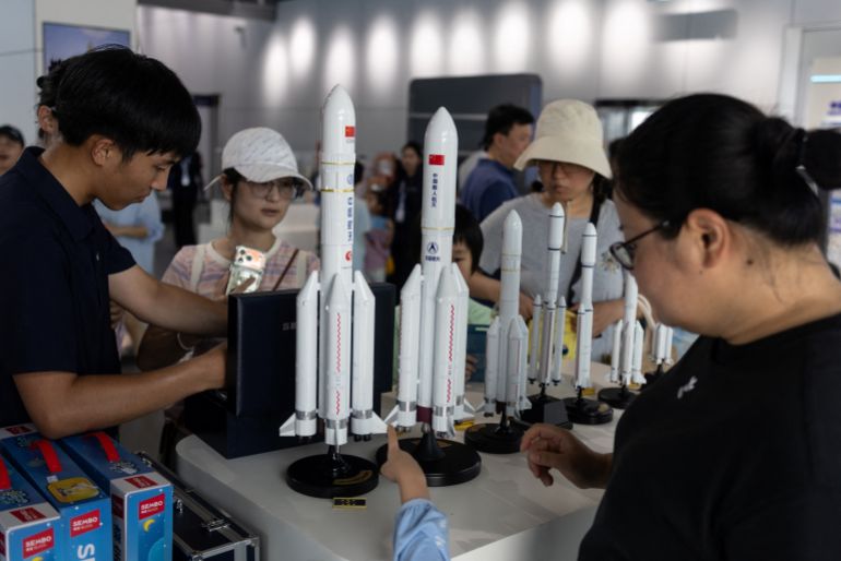 People look at models at a souvenir store at the Wenchang Aerospace Science and Education Center, in Wenchang, Hainan province, China, August 11, 2026. Once highly classified in remote deserts, China's space launches have increasingly been open to public viewing as the country's ambitions accelerate in a race with the United States. Plans include a crewed moon landing by 2030 followed by a crewed mission to Mars. REUTERS/Maxim Shemetov SEARCH "SHEMETOV CHINA SPACE" FOR THIS STORY. SEARCH "WIDER IMAGE" FOR ALL STORIES.