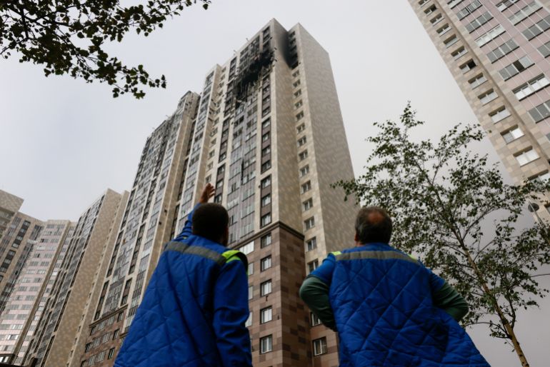A man points at a damaged multi-storey residential building hit by what authorities described as a Ukrainian drone strike, amid the Russia-Ukraine conflict in Kotelniki in the Moscow region, Russia, September, 20, 2026. REUTERS/Stringer