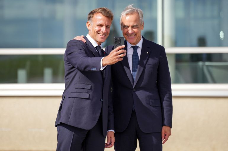 reuters_6ab54ff4-1790267380 France's President Emmanuel Macron and Canada's Prime Minister Mark Carney pose for a selfie as they meet in the small French territory of Saint Pierre and Miquelon, France September 20, 2026. REUTERS/Chris Tanouye