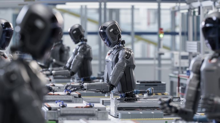 shutterstock_2691337679-1780830877 3D Render: Industrial AI Transformation: Advanced Human Like Robot Working in Industrial Environment. Autonomous AI Powered General Purpose Humanoid Robots Work at Factory on Assembly Line.