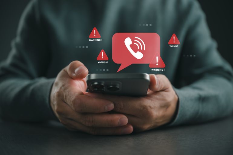 Person holding smartphone with warning call alert icons, representing phone scam, fraud detection, cyber crime awareness, mobile security risk, suspicious communication, digital safety protection.