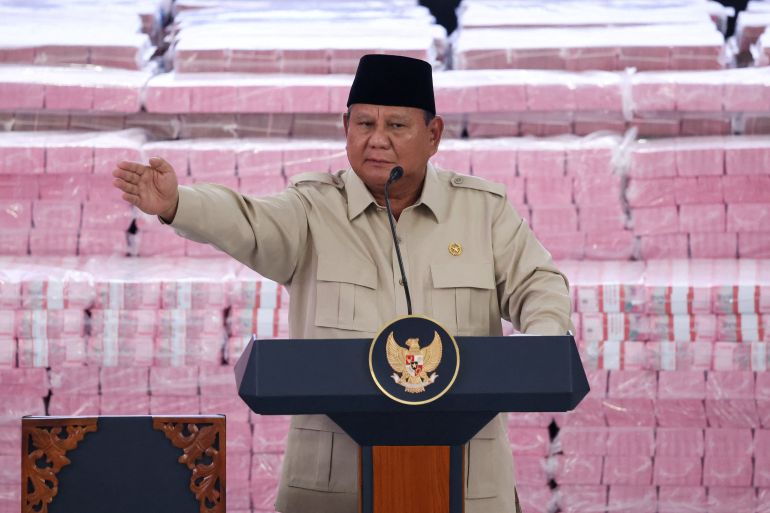 Indonesian President Prabowo Subianto gestures while delivering a speech in front of stacks of banknotes representing fines paid by companies found to have operated illegally in forest areas, during a ceremony marking the work of his forestry task force that has led to a crackdown on illegal plantations and mines, at the Indonesian Attorney General's Office in Jakarta, Indonesia, October 6, 2026. REUTERS/Ajeng Dinar Ulfiana (رويترز)