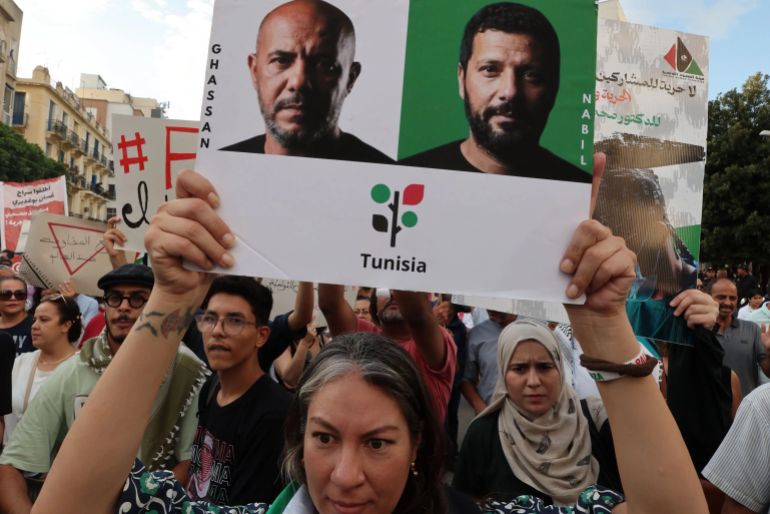 14sh6s8y4sh6-1790588111-e1790588136503 epa13250646 A Tunisian woman holds photos of four Tunisian members of the Sumud Flotilla, Wael Naouar (L-top), Ghassan Henchiri (R-top), Ghassan Boughdiri (L-bottom), and Nabil Chennoufi (R-bottom) during a demonstration organized by the Tunisian Republican Party in their support, in Tunis, Tunisia, 19 September 2026. The four members of the flotilla's leadership are detained at Mornaguia prison in pretrial detention since March 2026 as part of an investigation by the Economic and Financial Judicial Pole. A statement demanding their release and denouncing the criminalization of solidarity with the Palestinian people was signed by several associations. EPA/MOHAMED MESSARA