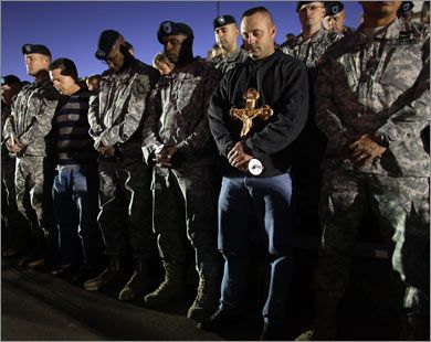 1_950549_1_34 U.S. Army soldiers bow their heads in prayer during a vigil for those killed and wounded when U.S. Army Major Nidal Malik Hasan went
