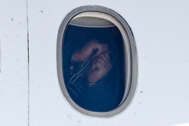 456-1791477327 A Venezuelan migrant in handcuffs appears in an aircraft window, as the flight carrying Venezuelan migrants deported from the United States arrives at Simon Bolivar International Airport, in Maiquetia, Venezuela, January 19, 2026. REUTERS/Marco Bello TPX IMAGES OF THE DAY