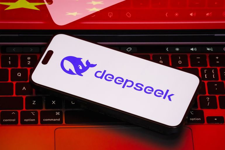 65yutfg-1761218532 CHONGQING, CHINA - FEBRUARY 19: A photo illustration shows a close-up of a smartphone displaying the deepseek logo on a white screen. The phone is placed on a laptop keyboard, with the same deepseek logo visible on the laptop. The background includes a subtle representation of the Chinese flag, highlighting the company's strong connection to China's tech industry. on February 19, 2025 in Chongqing, China. Deepseek, a cutting-edge AI platform developed by a Chinese tech company, is at the forefront of AI-driven search and data analytics, transforming the way users access and interact with information. (Photo by Cheng Xin/Getty Images)