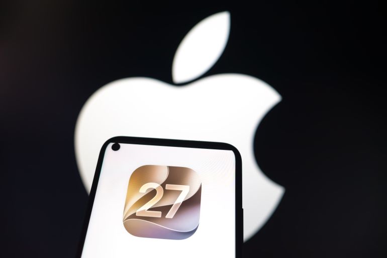 76984-3-1789904872 The Apple iOS 27 logo appears on a smartphone screen, and the Apple logo displays as the background on a laptop computer screen in this photo illustration in Athens, Greece, on June 9, 2026. Apple unveils iOS 27 during its Worldwide Developers Conference (WWDC) 2026, introducing updates focused on Apple Intelligence, enhancements to Siri, redesigned system apps, and user interface improvements across the iPhone ecosystem. (Photo by Nikolas Kokovlis/NurPhoto via Getty Images)