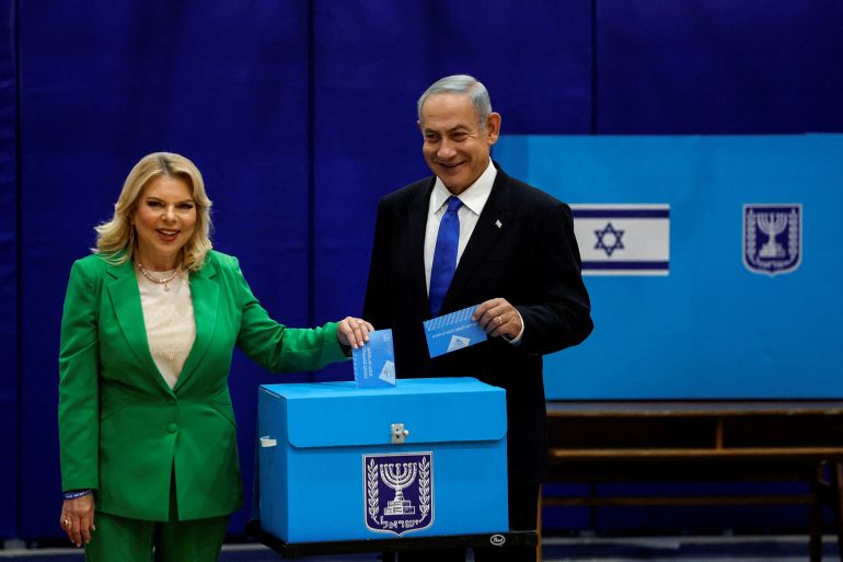 870689-1792518825 FILE PHOTO: Former Israeli Prime Minister Benjamin Netanyahu stands next to his wife Sara as they cast their ballots on the day of Israel's general election in a polling station in Jerusalem November 1, 2022. REUTERS/Ammar Awad/File Photo
