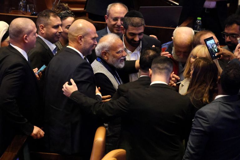 India's Prime Minister Narendra Modi (C) is greeted by Israeli lawmakers after his speech at the Israeli parliament, the Knesset, in Jerusalem on February 25, 2026. Modi told lawmakers in Jerusalem on February 25 that his country's economic growth and Israel's leadership in technological innovation formed a "natural foundation" for future partnership. (Photo by ilia YEFIMOVICH / AFP)