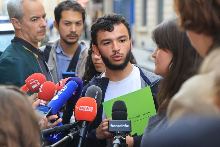 رياض راني المتحدث باسم الحراك الطلابي الفرنسي Secretary General of l'Union syndicale lycéenne (USL) Ryad Rani (C) speaks to the press following a meeting between representatives of student organisations and France's Education Minister in front of the ministry in Paris on October 2, 2026, amid student protests over a range of grievances that began last week. (Photo by Ludovic MARIN / AFP)