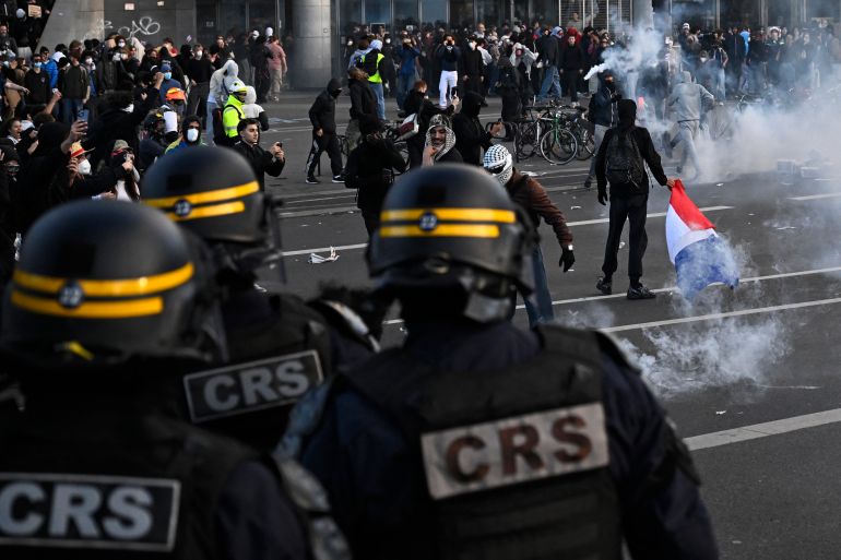 French Republican Security Corps (CRS - Compagnies Republicaines de Securite) police officers face protesters during a demonstration of high-school students at Place de la Bastille, in Paris, on October 8, 2026, as part of a nationwide protest movement over learning conditions. Since late September, pupils have barred the entrances to hundreds of schools, complaining of teacher absences, overloaded timetables, dilapidated classrooms and buildings ill-adapted to rising temperatures, among other grievances. (Photo by JULIEN DE ROSA / AFP)