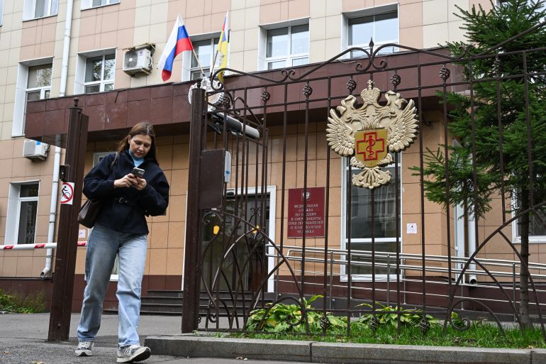 A woman leaves the grounds of the headquarters of Russia's consumer and health watchdog Rospotrebnadzor in Moscow on October 5, 2026.