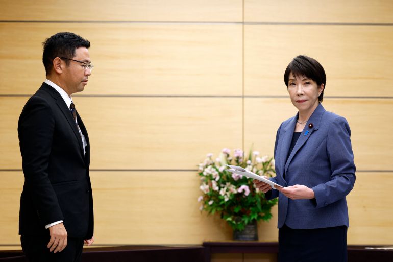 afp_6ac650554536-1791381589 Japanese Prime Minister Sanae Takaichi (R) holds a written request she received from Okinawa governor Genta Koja (L) ahead of their meeting at the prime minister’s office in Tokyo on October 7, 2026.