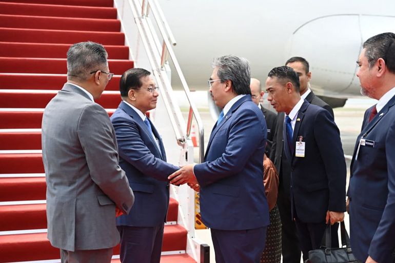 This handout photo taken and released by Myanmar's Presidential Press Information Bureau on October 7, 2026 shows Myanmar President Min Aung Hlaing (2nd L) being welcomed upon his arrival at Kuala Lumpur International Airport in Sepang. (Photo by Handout / Myanmar's Presidential Press and Information Bureau / AFP) / RESTRICTED TO EDITORIAL USE - MANDATORY CREDIT "AFP PHOTO / MYANMAR'S PRESIDENTIAL PRESS INFORMATION BUREAU" - HANDOUT - NO MARKETING NO ADVERTISING CAMPAIGNS - DISTRIBUTED AS A SERVICE TO CLIENTS