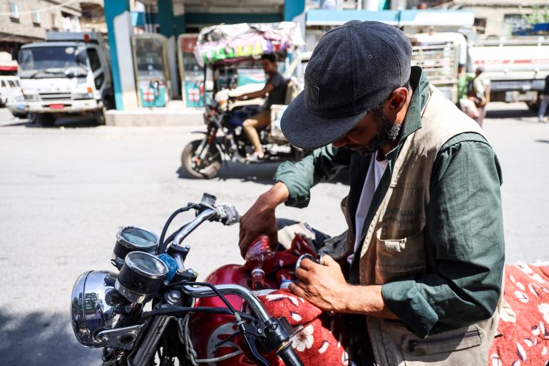 afp_6acd07058e81-1791821573 A Yemeni man fills his motorbike with fuel from a plastic bottle he just bought from a vendor along the roadside in the city of Taiz, on October 10, 2026.