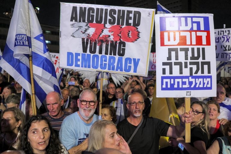 afp_6add0a195eb6-1792870937 Protesters gather with placards an anti-government demonstration demanding the formation of a state commission of enquiry into Hamas' 2023 October attacks at the Hostages Square in Tel Aviv on October 24, 2026, ahead of Israel's legislative election.