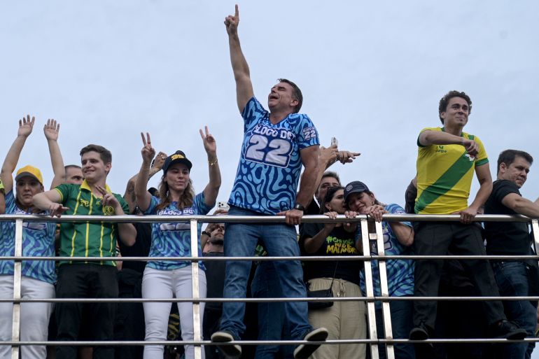 afp_6add8863af99-1792903267 Brazil's right-wing Senator and presidential candidate Flavio Bolsonaro (C) and deputy Nikolas Ferreira (2nd R) of the Liberal Party (PL) attend a rally in the Barra da Tijuca neighbourhood of Rio de Janeiro, Brazil, on October 24, 2026, ahead of the presidential election runoff. (Photo by TERCIO TEIXEIRA / AFP)
