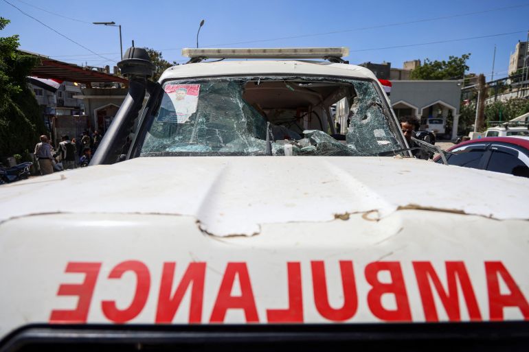 Yemeni people inspect a damaged ambulance in front of Al-Thawra General Hospital in Taiz on October 22, 2026, after it was towed from Al-Shaqab front in Sabir Al-Mawadim district, south of Taiz, where it was reportedly targeted the day before while carrying wounded people during battles between Saudi-backed Yemeni government fighters and Yemen's Iran-backed Houthis.