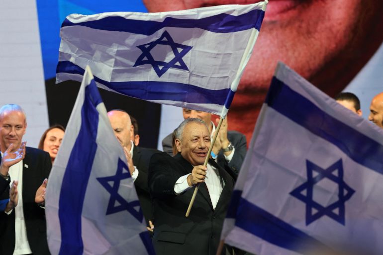 afp_6ae13cfc0368-1793146108 Yashar party leader Gadi Eisenkot waves Israel's national flag upon his arrival at the election night rally after the first exit polls were announced, in Tel Aviv on early October 28, 2026, during Israel's legislative elections.