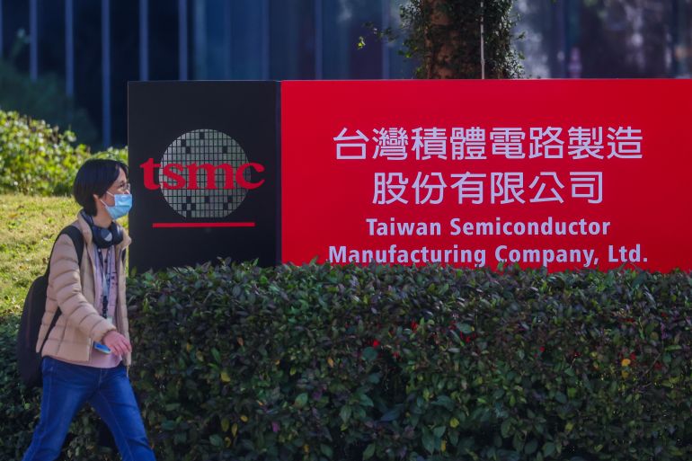 A woman walks past a building of TSMC or Taiwan Semiconductor Manufacturing Corp., a Taiwanese multinational semiconductor contract manufacturing and design company, in Hsinchu, Taiwan, on Thursday, Jan. 29, 2026. (AP Photo/Daniel Ceng)