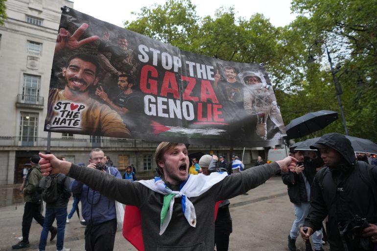 ap_6ac6a2d1e6abe-1791402705 A protester holds a placard to demand an end to what organisers describe as genocide in Gaza, marking three years since the 7 October attacks on Israel in London, Wednesday, Oct. 7, 2026.(AP Photo/Kin Cheung)