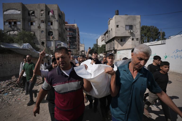 Mourners carry the body of Moamen Alay, who was killed in an Israeli airstrike, during his funeral in Gaza City Tuesday, Oct. 13, 2026. (AP Photo/Jehad Alshrafi)