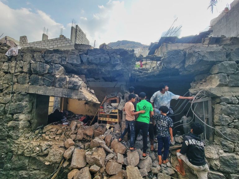 Residents walk amid debris from their homes after a missile strike in Seina, Taiz, Yemen, Tuesday, Oct. 20, 2026. (AP Photo/Marzouq Al Jabri)