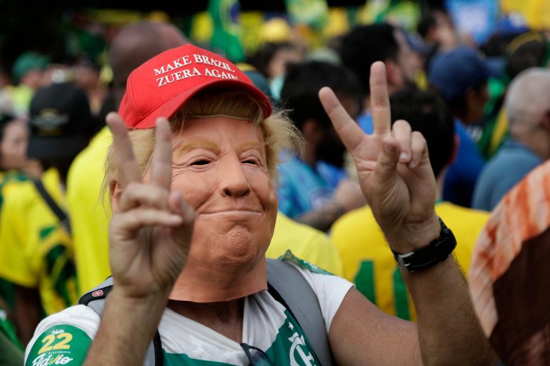 ap_6add87f656f83-1792903158 A supporter wears a mask depicting U.S. President Donald Trump during opposition presidential candidate Sen. Flavio Bolsonaro's final campaign rally ahead of Brazil's presidential runoff election in Rio de Janeiro, Brazil, Saturday, Oct. 24, 2026. (AP Photo/Bruna Prado)