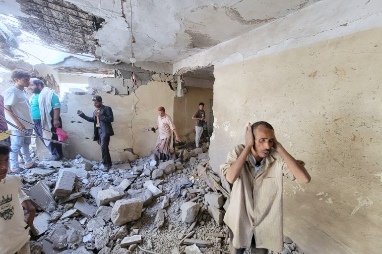 Residents walk on debris of their homes at Seina district in Taiz, Yemen, after a missile strike, Tuesday, Oct. 20, 2026. (AP Photo/Marzouq Al Jabri)