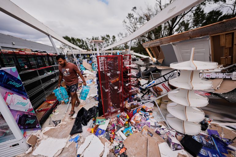 Islam Mahfuz salvages contents of their destroyed mini mart in the aftermath of Hurricane Isaias in Milton, Fla., Saturday, Oct. 10, 2026. (AP Photo/Gerald Herbert) (AP)
