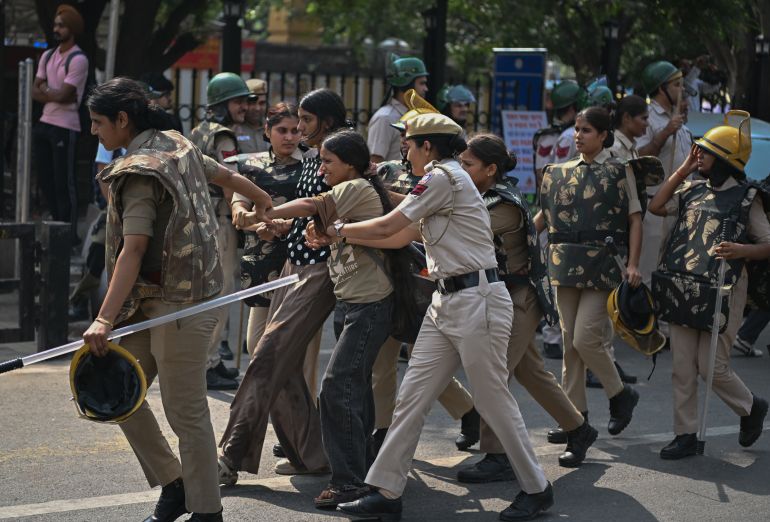 getty_6aca85251d-1791657253 NEW DELHI, INDIA - OCTOBER 10: Police officers detain a protester during a anti-government rally on October 10, 2026 in New Delhi, India. The Cockroach Janta Party (CJP) has called a mass protest to demand the resignation of India's Chief Election Commissioner, Gyanesh Kumar, over what they say are alleged irregularities in electoral processes and the revision of voter rolls. (Photo by Ritesh Shukla/Getty Images)