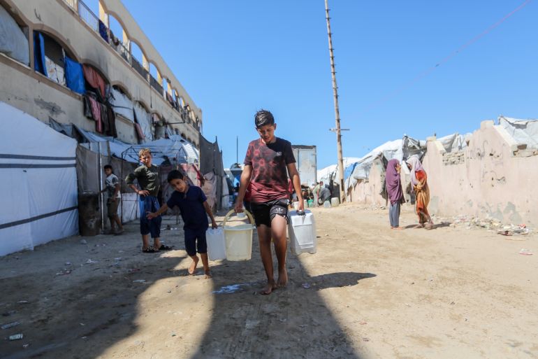 getty_6acdb9cdee-1791867341 GAZA CITY, GAZA - OCTOBER 7: Displaced children carry water containers on October 7, 2026 in Gaza City, Gaza, on the third anniversary of the Hamas-led 2023 attacks that sparked Israel's devastating war of retaliation in Gaza. A humanitarian crisis now prevails in the Palestinian territory, with most of its population having been displaced in the last three years. A purported ceasefire was agreed to in October 2025, but Israel has continued aerial attacks multiple times per week, citing the threat posed by Hamas. Last week, Gaza's Health Ministry declared that the Palestinian death toll from the war had surpassed 74,000. (Photo by Ahmad Hasaballah/Getty Images)