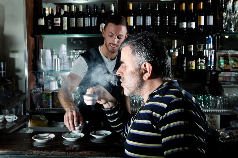 gettyimages-107191984-1733846524 A man enjoys his hot coffee or espresso in a bar. It looks classical and tasty. He really enjoys the drink and his break.