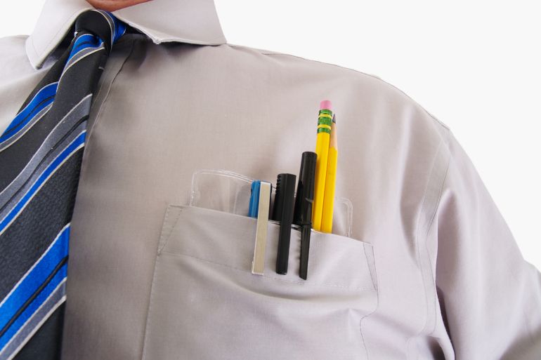 a man working with a pens, pencils, in a pocket protector isolated on white.
