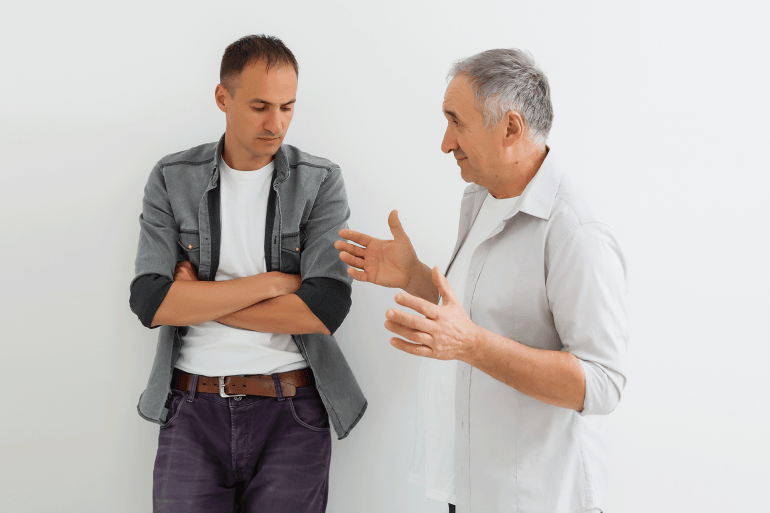 Senior Father With Adult Son on a white background شخصان يتكلمان مع بعضهما وأحدهما لا يشعر بالارتياح